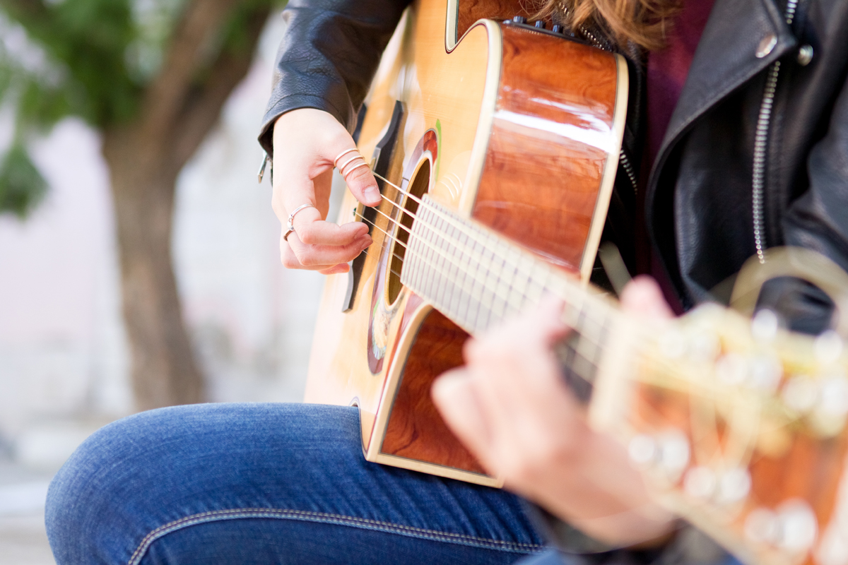 Closeup of acoustic guitar and woman hands on strings. Music and creative concept