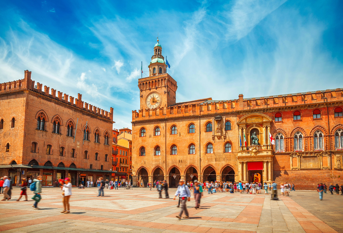 Italy Piazza Maggiore in Bologna old town tower of town hall with big clock and blue sky on background, antique buildings terracotta galleries