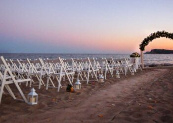 Allestimento di un matrimonio in riva al mare al tramonto. 📷 AdobeStock | alex.pin
