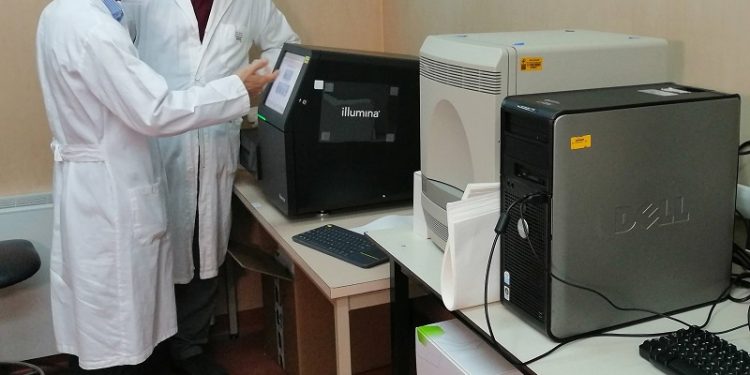 Il prof. Rubino e il prof. Uzzau di lato al macchinario per sequenziare virus