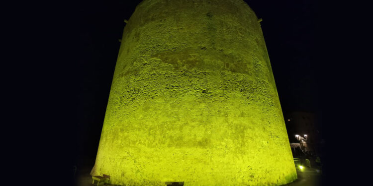 La Torre di Sulis illuminata di giallo