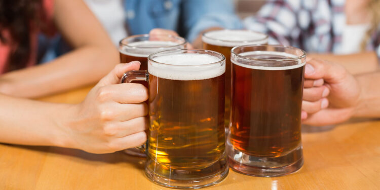 Amici che brindano con la birra. 📷 Depositphotos