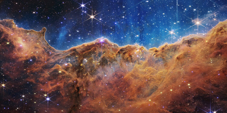 Nebulosa Carina. Scogliere cosmiche e un mare di stelle. Il telescopio spaziale James Webb della NASA rivela piccole stelle nella nebulosa Carina, dove le radiazioni ultraviolette e i venti stellari formano pareti colossali di polvere e gas. ? NASA