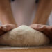 Mani che impastano il pane. 📷 Depositphotos