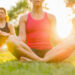 Donne che fanno yoga nel parco. ? Depositphotos