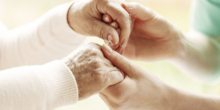 Infermiera tiene mani anziana. ? Depositphotos