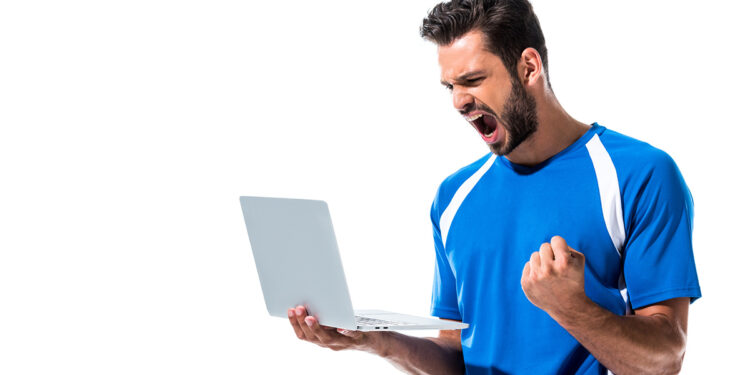 Ragazzo guarda lo sport sul computer. ? Depositphotos