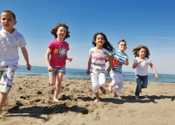 Bambini giocano sulla spiaggia. ? Depositphotos