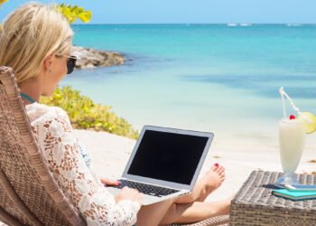 Donna spiaggia computer. 📷 Depositphotos