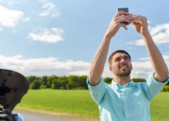 Ragazzo macchina in panne telefono no segnale. 📷 Depositphotos