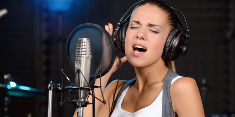Ragazza che registra canzone in studio. ? Depositphotos