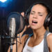 Ragazza che registra canzone in studio. ? Depositphotos