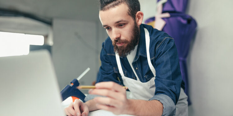 Artigiano progetta al computer. ? Depositphotos