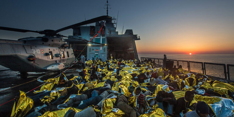 Operazione Mare Nostrum, salvataggio di naufraghi a bordo di un barcone da parte della fregata FREMM Bergamini della Marina Militare. ? Massimo Sestini