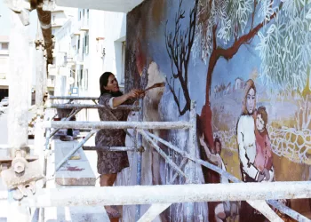 Liliana Cano mentre dipinge il “Murale dei Combattenti” di Ozieri (1971)