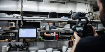 Riprese di The Lunch nella cucina di un diner, con il cuoco dietro il banco e una videocamera in primo piano